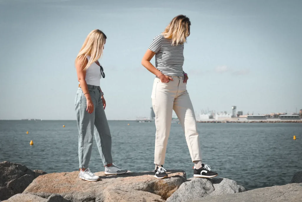 Pareja sobre las rocas junto al mar con zapatillas Ston Agona